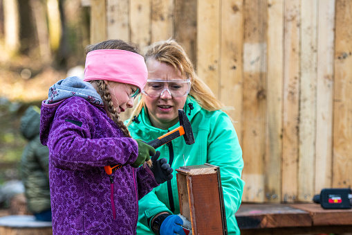 Jente med hammer utendørs i aktivitet